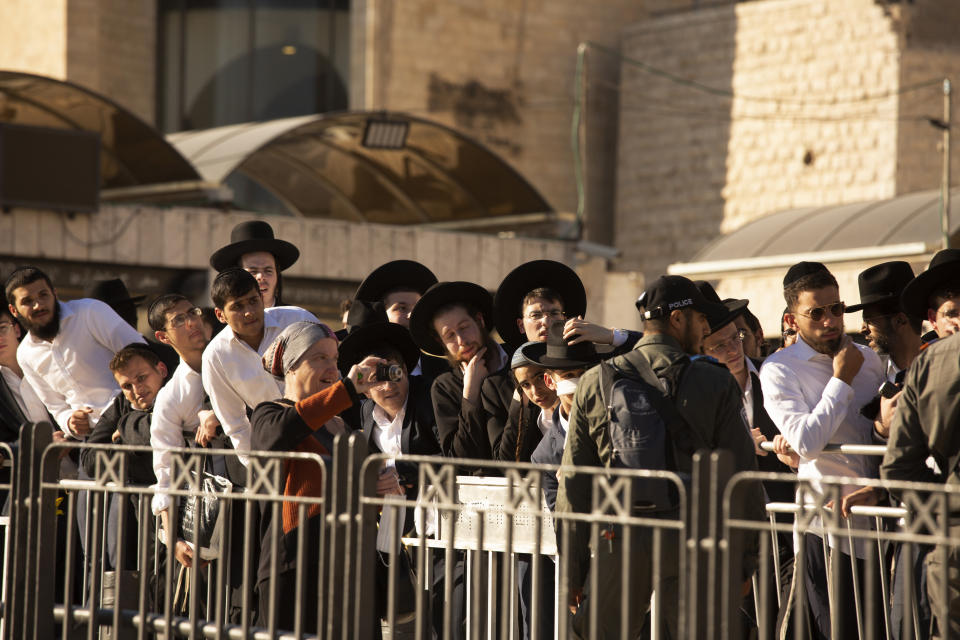 Protesters are cordoned behind a security fence are gathered at the Western Wall, the holiest site where Jews can pray, waiting for Women of the Wall to arrive for their monthly prayer in the Old City of Jerusalem, Friday, Nov. 5, 2021. Thousands of ultra-Orthodox Jews gathered at the site to protest against the Jewish women's group that holds monthly prayers there in a long-running campaign for gender equality at the site. (AP Photo/Maya Alleruzzo)