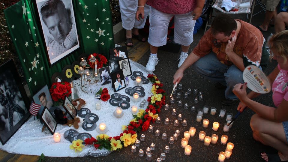 Stephen Galvin from Bryan, Texas, lights candles arranged to spell out "Elvis 30" beside Elvis Presley memorabilia during a vigil in memory of the late singer outside the front gates of Graceland Mansion, the home of Elvis Presley, on August 15, 2007, in Memphis, Tennessee. - Joe Raedle/Getty Images