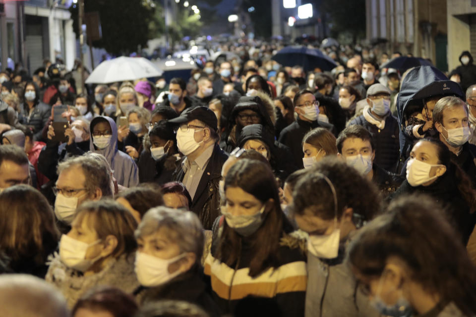 People attend a memorial march in homage to the history teacher who was beheaded last week, Tuesday, Oct.20, 2020 in Conflans-Sainte-Honorine, northwest of Paris. Samuel Paty was beheaded on Friday by an 18-year-old Moscow-born Chechen refugee, who was later shot dead by police. Police officials said Paty had discussed caricatures of Islam's Prophet Muhammad with his class, leading to threats. (AP Photo/Lewis Joly)