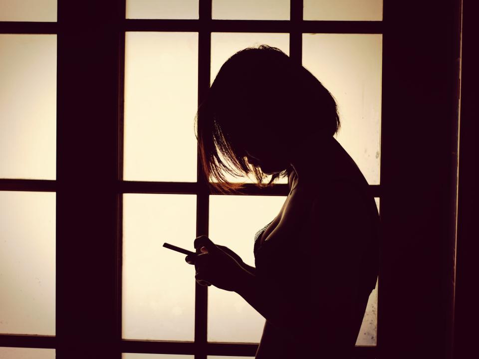 silhouette of woman using phone