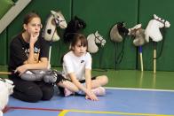 Participants watch races of their competitors during a Hobby horsing competition in St. Petersburg, Russia, on Sunday, April 21, 2024. Several dozen kids, 48 girls and one boy, from first-graders to teenagers gathered in a gymnasium in northern St. Petersburg, Russia's second largest city, for a hobby horsing competition. (AP Photo/Dmitri Lovetsky)