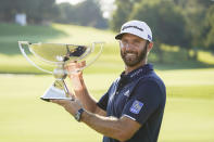 Dustin Johnson celebrates with the FedEx Cup trophy after winning the Tour Championship golf tournament on Monday, Sept. 7, 2020 at Lake Golf Club in Atlanta. (AP Photo/John Bazemore)