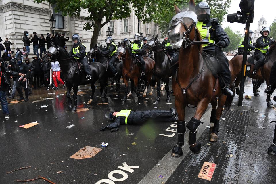 A mounted police officer lays on the road after being unseated from their horse, during a demonstration on Whitehall, near the entrance to Downing Street in central London on June 6, 2020, to show solidarity with the Black Lives Matter movement in the wake of the killing of George Floyd, an unarmed black man who died after a police officer knelt on his neck in Minneapolis. - The United States braced Friday for massive weekend protests against racism and police brutality, as outrage soared over the latest law enforcement abuses against demonstrators that were caught on camera. With protests over last week's police killing of George Floyd, an unarmed black man, surging into a second weekend, President Donald Trump sparked fresh controversy by saying it was a "great day" for Floyd. (Photo by DANIEL LEAL-OLIVAS / AFP) (Photo by DANIEL LEAL-OLIVAS/AFP via Getty Images)