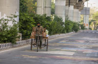 NEW DELHI, INDIA - MARCH 26: An Indian man carrying sacks of vegetables paddles his tricycle on a deserted road, as nationwide lockdown continues over highly contagious novel coronavirus on March 26, 2020 in New Delhi, India. India is under a 21-day lockdown to fight the spread of Covid-19 infections and while the security personnel on the roads are enforcing the restrictions in many cases by using force, the workers of country's unorganized sector are bearing the brunt of the curfew-like situation. According to the international labour organisations India's 90% workforce is employed in the informal sector and most do not have access to pensions, sick leave, paid leave or any kind of insurance. Reports on Thursday said that Prime Minister Narendra Modi's government is preparing a massive bailout to reach to the underprivileged sections of the country and will hand over the dole through direct cash transfers. (Photo by Yawar Nazir/Getty Images)