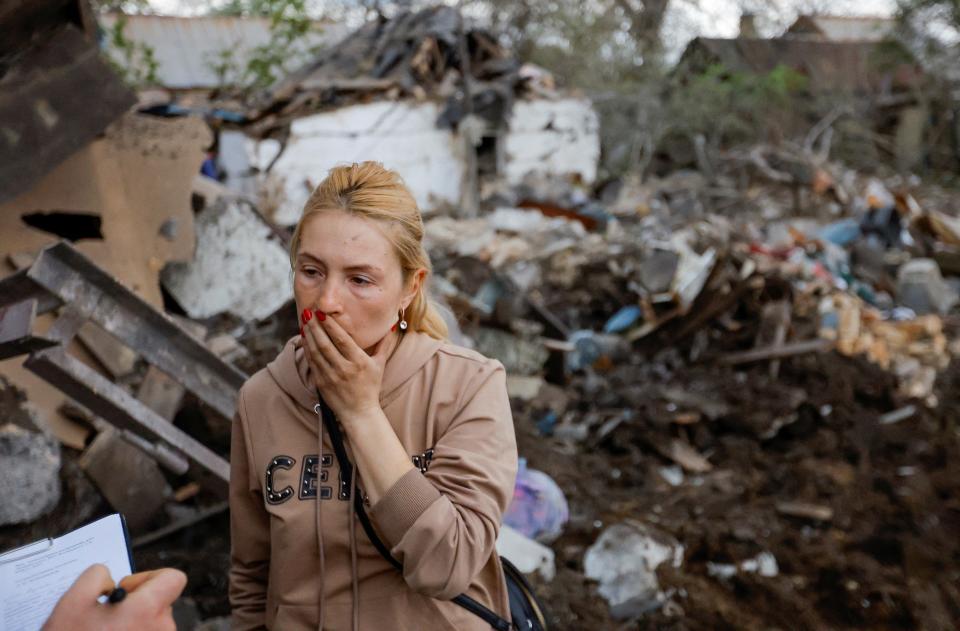 A local resident speaks with an investigator outside her house, which was destroyed by shelling in the course of Russia-Ukraine conflict in Donetsk (REUTERS)