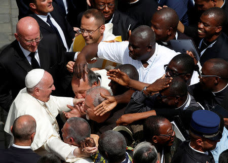 FILE PHOTO : Pope Francis (L) is greeted by priests at the end of a mass for the Jubilee of Priests at St. Peter's Square at the Vatican June 3, 2016. REUTERS/Alessandro Bianchi/File Photo