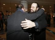 Canadian Greenpeace activist Alexandre Paul (R) is greeted after arriving at Montreal's airport, December 27, 2013. Paul was detained by Russia for more than three months following a protest against Arctic oil drilling in international waters. REUTERS/Christinne Muschi (CANADA - Tags: CIVIL UNREST ENVIRONMENT CRIME LAW)