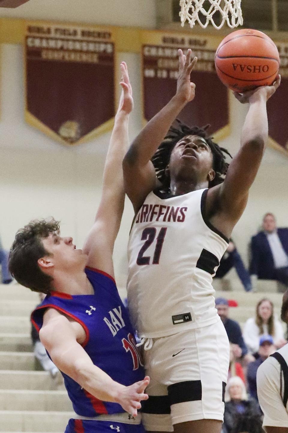 Bay Village's Brandon Knaack defends as Buchtel's Khoi Thurmon shoots in the Division II district semifinal boys basketball game at Stow-Munroe High School on Wednesday. Buchtel beat Bay Village 83-41.