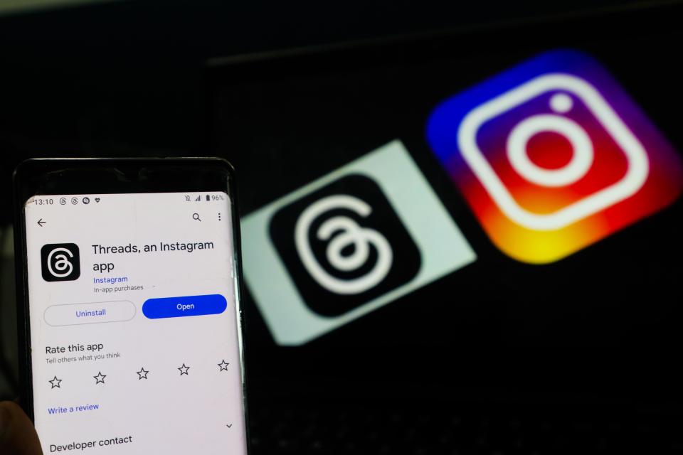 A picture of a phone with the Threads and Instagram logos in the background.