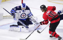 Winnipeg Jets goaltender Laurent Brossoit (30) makes a save on Ottawa Senators' Ryan Dzingel (10) during the second period of an NHL hockey game Wednesday, April 14, 2021, in Ottawa, Ontario. (Sean Kilpatrick/The Canadian Press via AP)