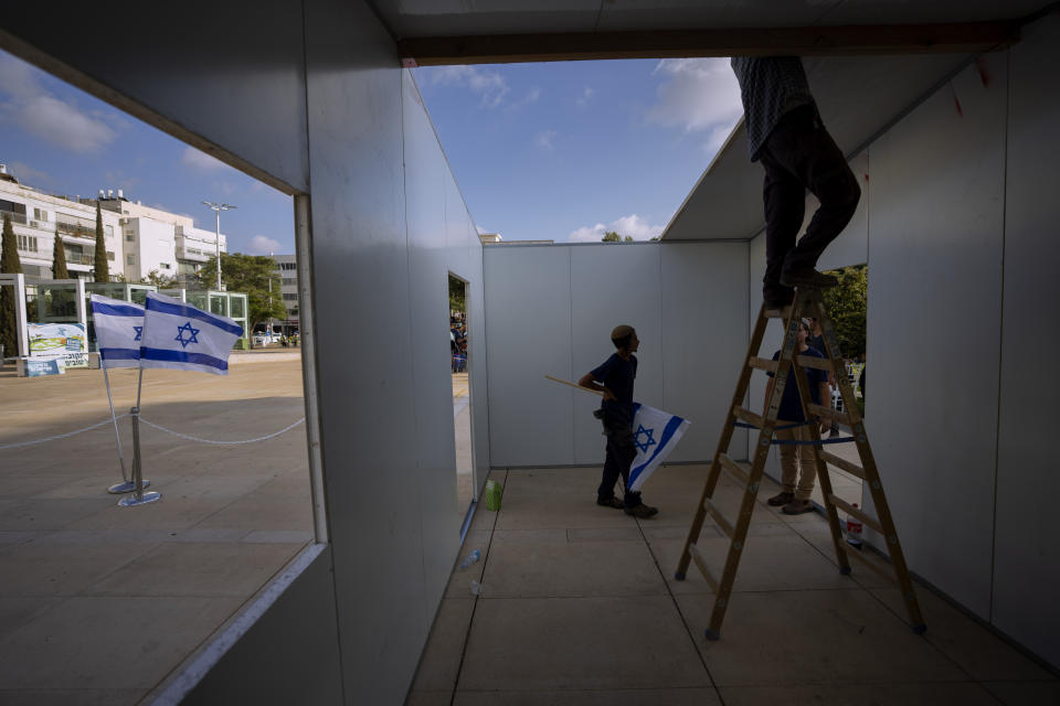 Right wing Israeli activists from the Nachala Settlement Movement erect a temporary structure as part of a protest calling for the establishment of new Jewish settlements in the occupied West Bank, at Habima Square in Tel Aviv, July 12, 2022. The Israeli Supreme Court on Wednesday July 27, 2022, has cleared the way for residents of the Jewish West Bank settlement outpost of Mitzpe Kramim to remain in their homes, overturning an earlier eviction order that determined the land had been bought illegally. Palestinians fear this could set a precedent for future disputes over Jewish settlements being built on privately owned Palestinian land. (AP Photo/Oded Balilty)