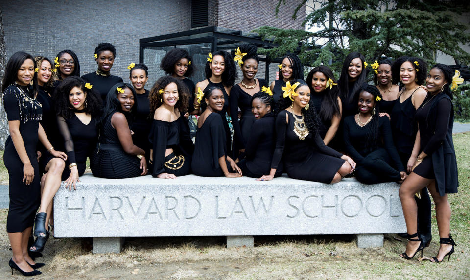 Harvard Law School women posing with yellow flowers in their hair that represent “friendship, filial love, warmth, compassion, and gentleness,” as explained by Jazzmin Carr. (Photo: Will Sterling)