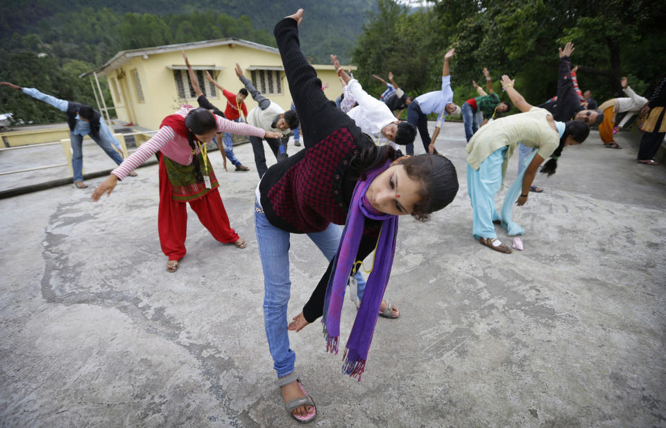 In this Aug. 25, 2012 photo, employees exercise together at the beginning of their working day on the roof of B2R center in Simayal, India. Before B2R arrived in Simayal, local women had little option but to marry right out of school, and educated young men had to travel far to seek respectable jobs. (AP Photo/Saurabh Das)