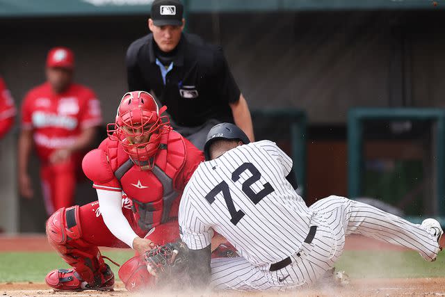 <p>Hector Vivas/Getty</p> Oscar Gonzalez sliding into home plate on March 25