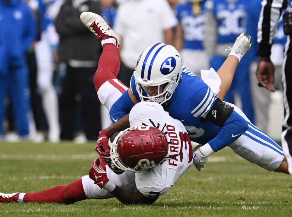 Brigham Young Cougars safety Crew Wakley (38) brings down Oklahoma Sooners wide receiver Jalil Farooq (3) as BYU and Oklahoma play at LaVell Edwards Stadium in Provo on Saturday, Nov. 18, 2023.
