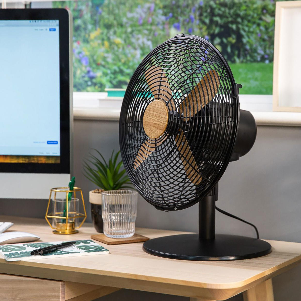  Russell hobbs scandi wood effect desk fan on a desk with a computer. 