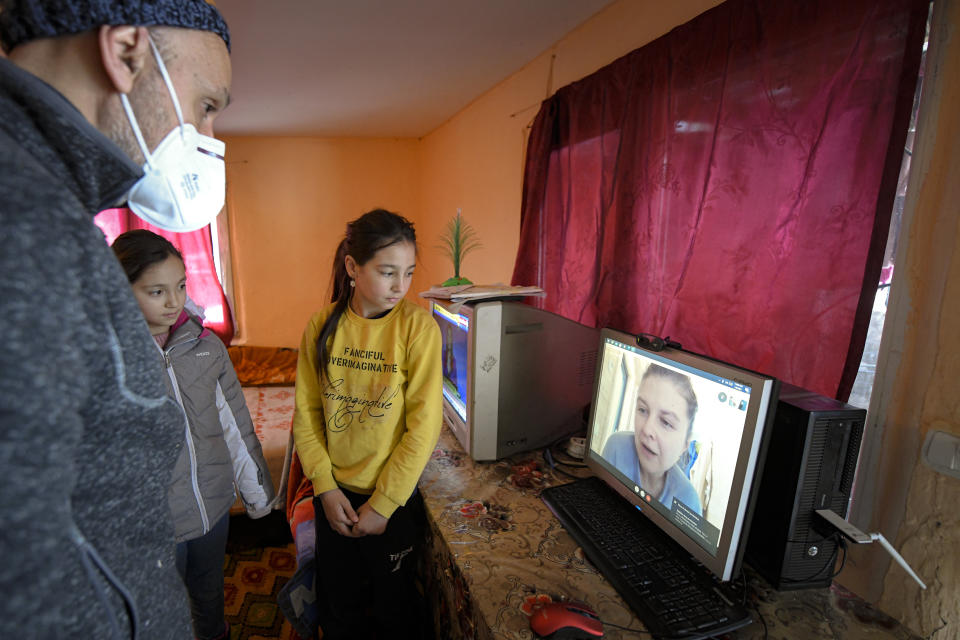 Children join Valeriu Nicolae on a video call with a voluteer that assists with homeschooling, on a computer provided by the Good House, or Casa Buna in Romanian, an association he leads helping underprivileged children have access to education, in Nucsoara, Romania, Saturday, Jan. 9, 2021. Nicolae and his team visited villages at the foot of the Carpathian mountains, northwest of Bucharest, to deliver aid. The rights activist has earned praise for his tireless campaign to change for the better the lives of the Balkan country’s poorest and underprivileged residents, particularly the children. (AP Photo/Andreea Alexandru)