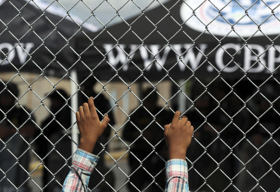 A migrant leans on a fence of the Gateway International Bridge that connects downtown Matamoros, Mexico with Brownsville, Thursday, Oct. 10, 2019. Migrants wanting to request asylum camped out on the international bridge leading from Mexico into Brownsville, Texas, causing a closure of the span. (AP Photo/Fernando Llano)