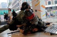 Riot police officers detain an anti-government protester in Tsuen Wan, near the site where police shot a protester with live ammunition on China's National Day in Hong Kong