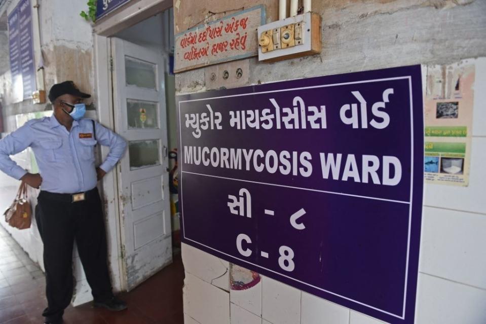 A security guard stands at the entrance of a ward for people infected with Black Fungus or scientifically known as Mucormycosis, a deadly fungal infection, at a civil hospital in Ahmedabad