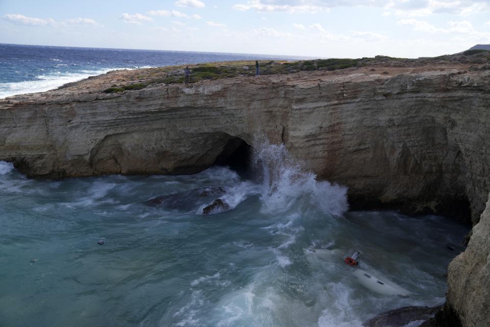 The remains of a sailboat is seen in the water after it smashed into rocks and sank off the island of Kythira, southern Greece, Thursday, Oct. 6, 2022. Residents of a Greek island pulled shipwrecked migrants to safety up steep cliffs in dramatic rescues after two boats sank in Greek waters, leaving at least 21 people dead and many still missing. (AP Photo/Thanassis Stavrakis)