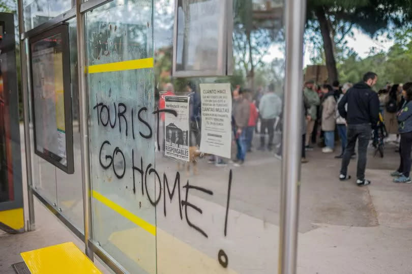 Photo shows tourists go home sign