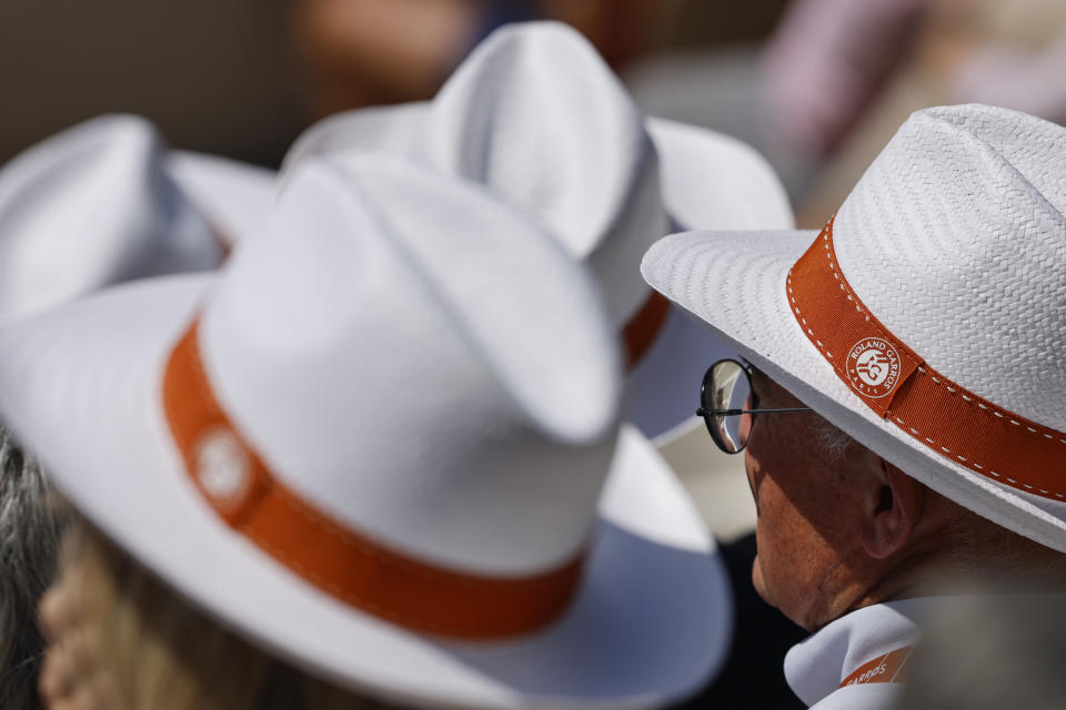 Spectators shield themselves from the sun with hats as they watch Australia's Thanasi Kokkinakis and Switzerland's Stan Wawrinka during their second round match of the French Open tennis tournament at the Roland Garros stadium in Paris, Wednesday, May 31, 2023. (AP Photo/Jean-Francois Badias)