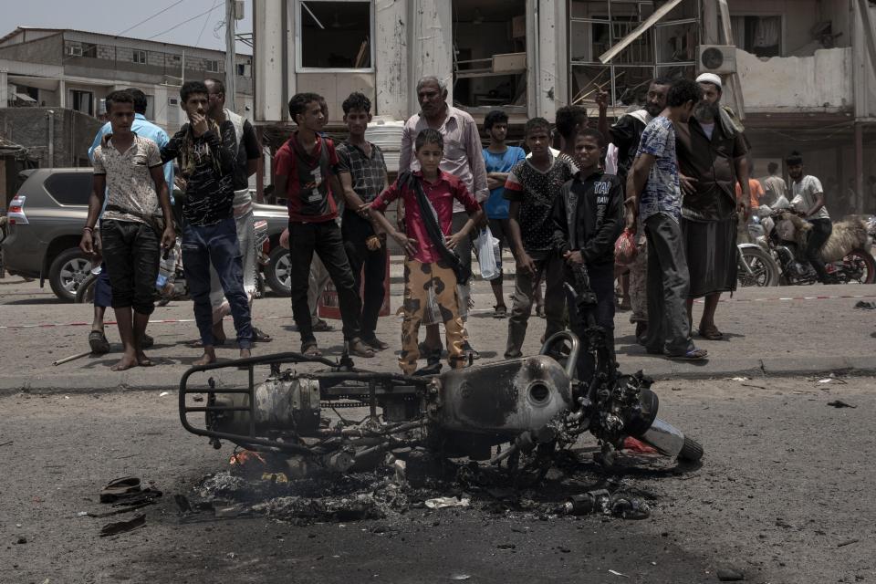 Civilians gather at the site of a deadly attack in Aden, Yemen, Thursday, Aug. 1, 2019. Yemen's rebels have fired a ballistic missile at a military parade in the southern port city of Aden as coordinated suicide bombings targeted a police station in another part of the city. The attacks killed at least 51 people and wounded dozens. (AP Photo/Nariman El-Mofty)