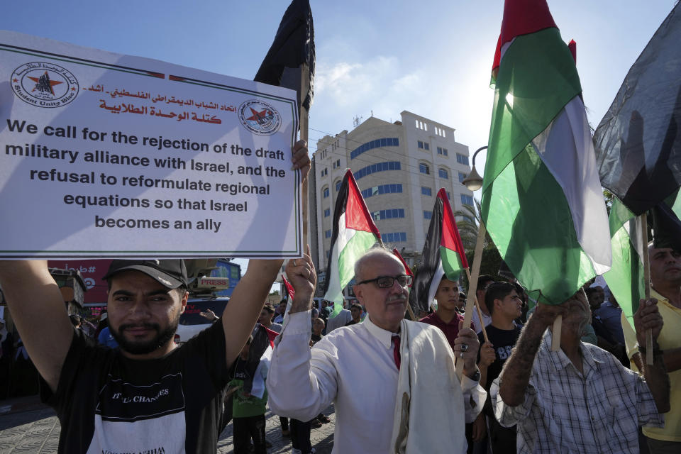 Residents wave their national flags during a protest against U.S. President Joe Biden's visit to the region, at the Unknown Soldier square in Gaza City, Thursday, July 14, 2022. (AP Photo/Adel Hana)