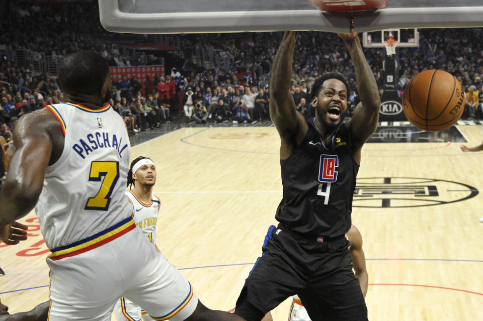 Los Angeles Clippers forward JaMychal Green, right, dunks as Golden State Warriors forward Eric Paschall defends during the second half of an NBA basketball game Friday, Jan. 10, 2020, in Los Angeles. The Clippers won 109-100. (AP Photo/Mark J. Terrill)