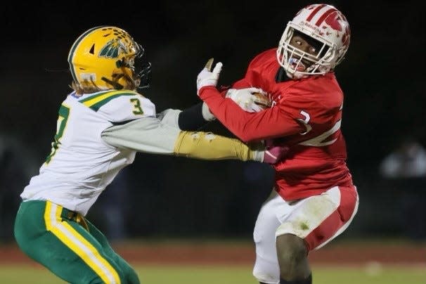 Laurel's Kylse Wilson carries as Indian River's Hayden Hall tries to bring him down.