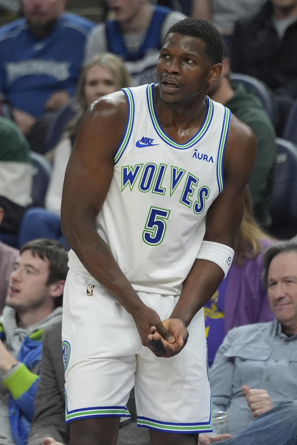Minnesota Timberwolves guard Anthony Edwards (5) grabs his hand during the first half of an NBA basketball game against the Denver Nuggets, Tuesday, March 19, 2024, in Minneapolis. (AP Photo/Abbie Parr)