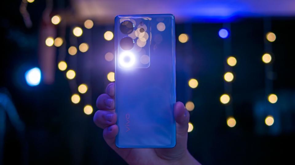 A smartphone in hand, surrounded by a mesmerizing backdrop of vibrant lights