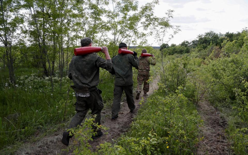 Service members of pro-Russian troops carry leaflet shells at their combat positions in the Luhansk region - ALEXANDER ERMOCHENKO /REUTERS