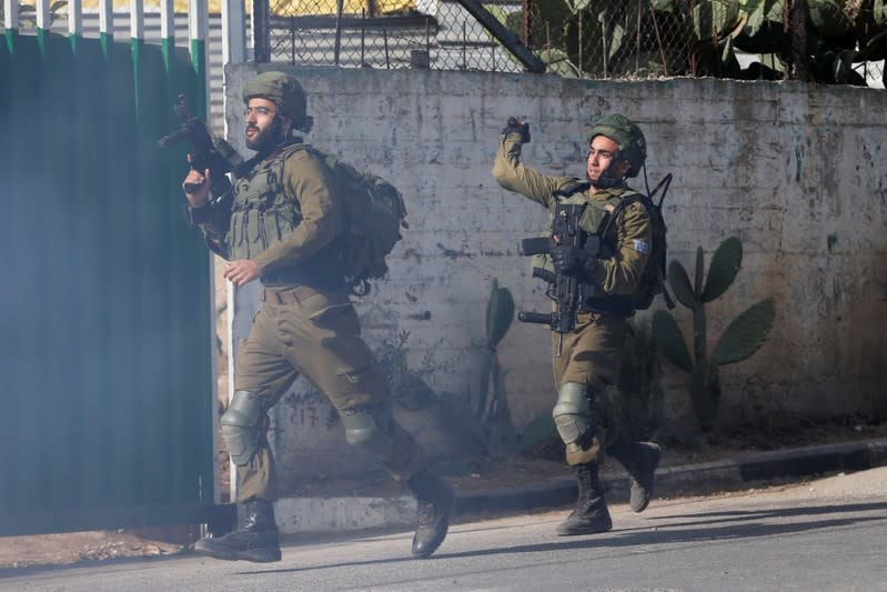 Israeli soldiers run during an anti-Israel protest by Palestinians in al-Arroub refugee camp, in the Israeli-occupied West Bank