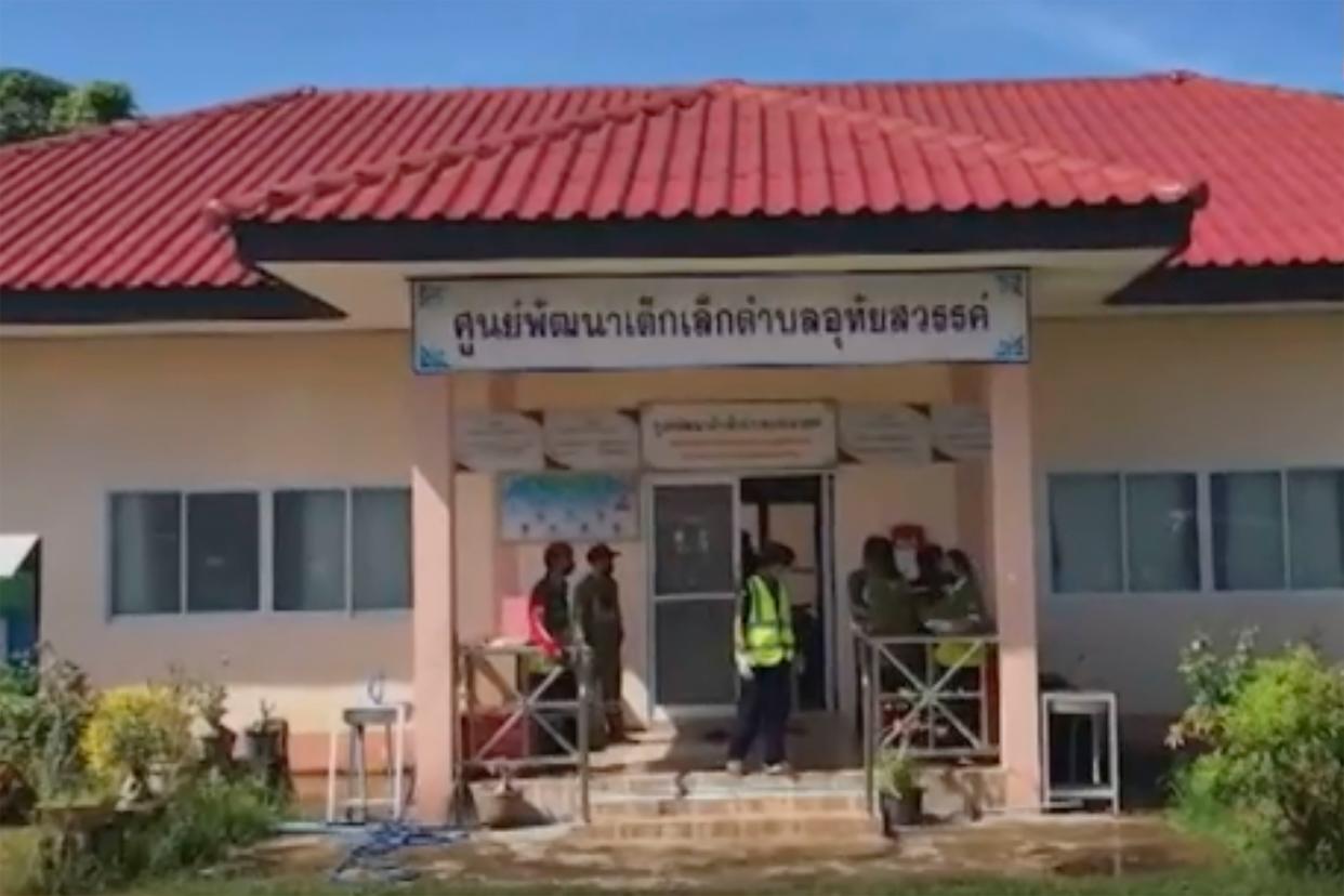 In this image taken from video, officials enter the site of an attack at a daycare center, Thursday, Oct. 6, 2022, in the town of Nongbua Lamphu, north eastern Thailand. More than 30 people, primarily children, were killed Thursday when a gunman opened fire the childcare center authorities said.