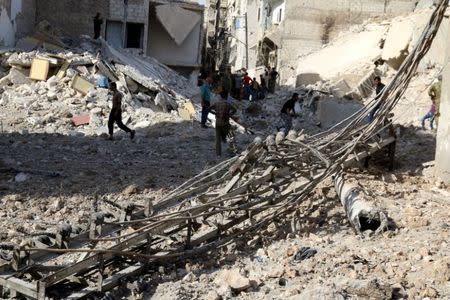 People inspect a damaged site after airstrikes in the rebel held Karam Houmid neighbourhood in Aleppo, Syria October 4, 2016. REUTERS/Abdalrhman Ismail