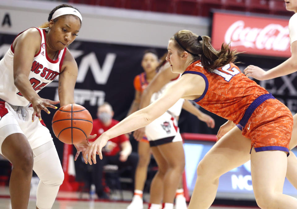 North Carolina State's Kayla Jones (25) steals the ball from Clemson's Hannah Hank (12) during the first half of an NCAA college basketball game at Reynolds Coliseum in Raleigh, N.C., Thursday, Feb. 11, 2021. (Ethan Hyman/The News & Observer via AP)