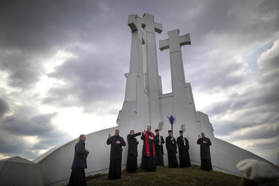 Archbishop Gintaras Grusas, center, speaks during the Holy Week procession at the Three Crosses hill in Vilnius, Lithuania, Friday, April 7, 2023. Holy Week commemorates the last week of the earthly life of Jesus Christ culminating in his crucifixion on Good Friday and his resurrection on Easter Sunday. (AP Photo/Mindaugas Kulbis)