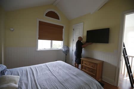 Alex Vybourg of audio visual integration company SpeakerGuy Inc. looks at a audio visual equipment he installed in a home in Manhattan Beach, California, July 29, 2014. REUTERS/Lucy Nicholson