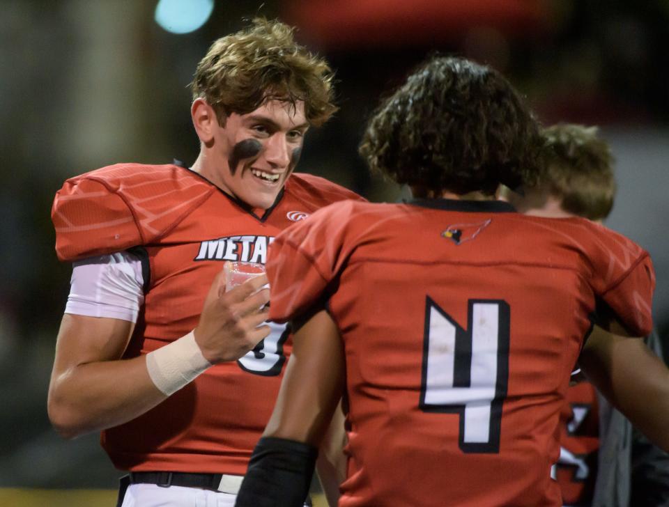 Metamora quarterback Kaden Hartnett, facing, talks with running back Kam Davis during a break in the action against Canton on Friday, Sept. 23, 2022 in Metamora.