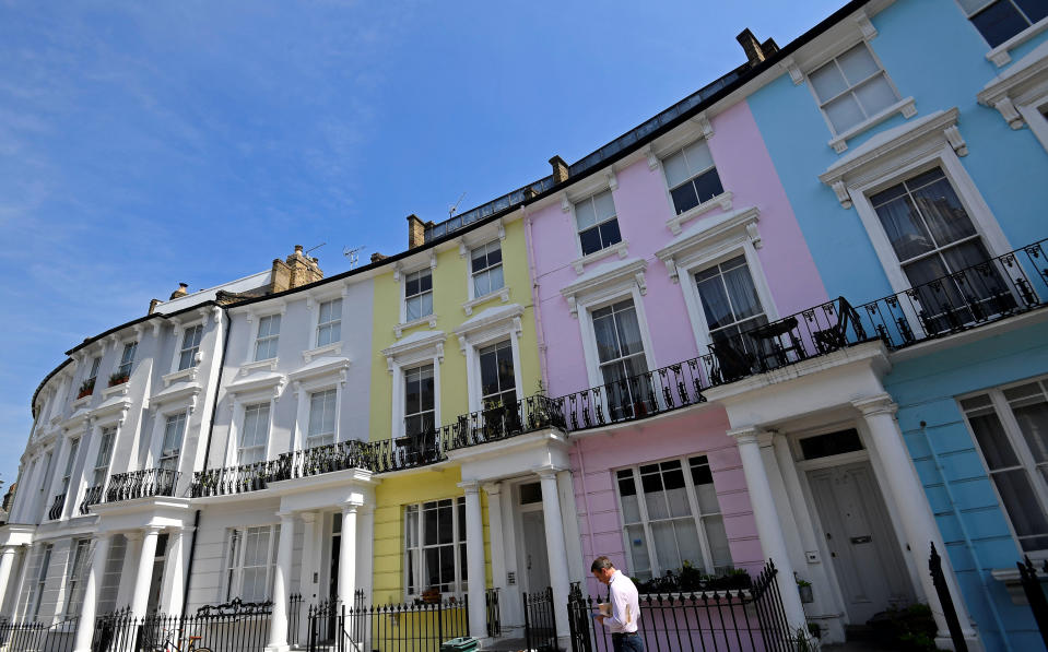 Mortgage  A man walks past houses painted in various colours in a residential street in London, Britain, May 15, 2019. REUTERS/Toby Melville