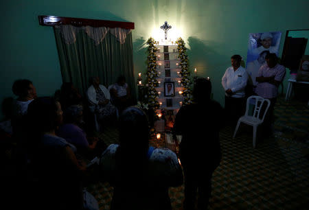 Griselda Barradas, relatives and friends pray for her son Pedro Alberto Huesca, whose remains were found at one of the unmarked graves where skulls were found on a plot of land, in Palmas de Abajo, Veracruz, Mexico March 16, 2017. REUTERS/Carlos Jasso