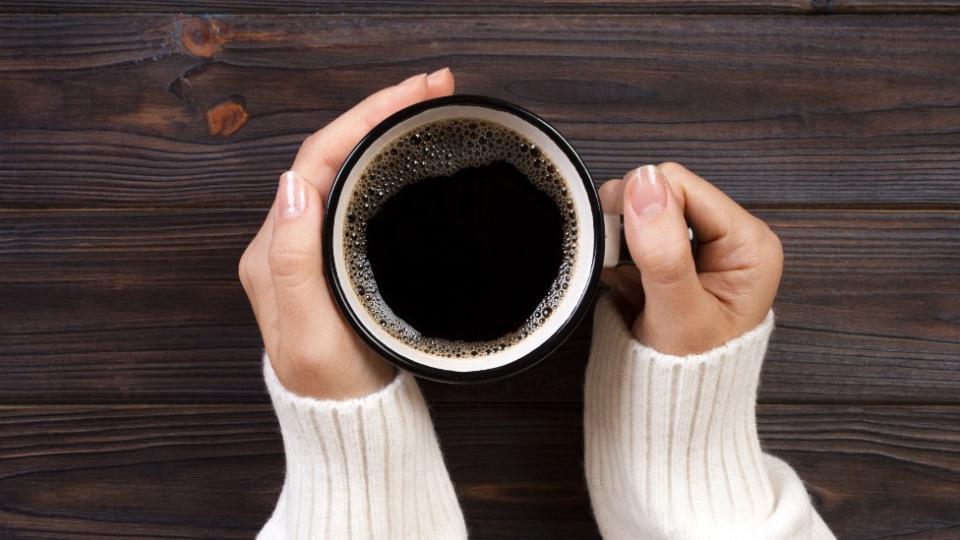 Una joven tiene entre sus manos una taza de café