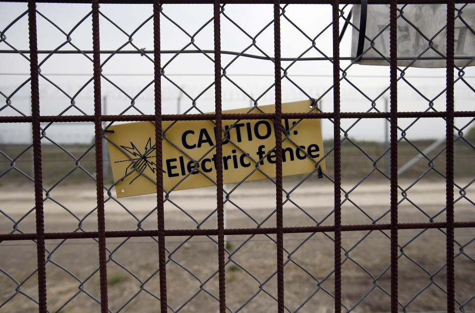 In this photo taken Monday, April 8, 2019, a warning sign is attached to a fence at Hungary's border with Serbia near the village Asotthalom, Hungary. With a campaign centered on stopping immigration, Hungary’s ruling Fidesz party is expected to continue its dominance in the European Parliament election at the end of May. While Hungary has been practically closed to immigrants from the Middle East, Asia and Africa since Prime Minister Viktor Orban had border fences built in 2015, he continues to warn voters about the threat of a “migrant invasion” that would put at risk Europe’s Christian culture. (AP Photo/Darko Vojinovic)