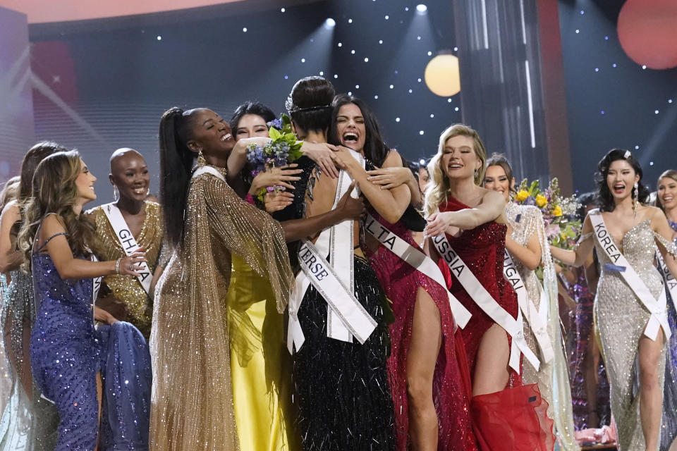 Miss Estados Unidos R'Bonney Gabriel, de espaldas a la cámara en el centro, es abrazada por otras concursantes tras ser coronada Miss Universo en la 71a edición de Miss Universo en Nueva Orleans el sábado 14 de enero de 2023. (Foto AP/Gerald Herbert)