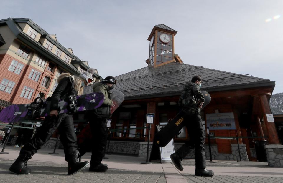 Snowboarders walk to a ski lift in the Heavenly Village commercial complex in South Lake Tahoe.