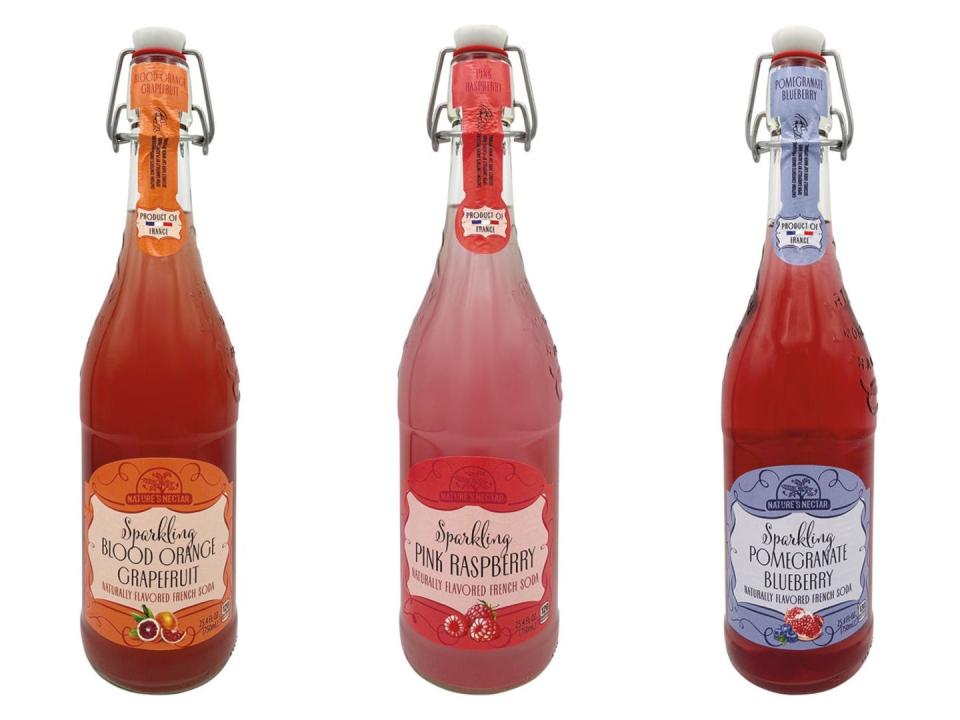 Three bottles of Nature's Nectar sparkling French sodas in blood-orange-grapefruit, pink-raspberry, and pomegranate-blueberry flavors.