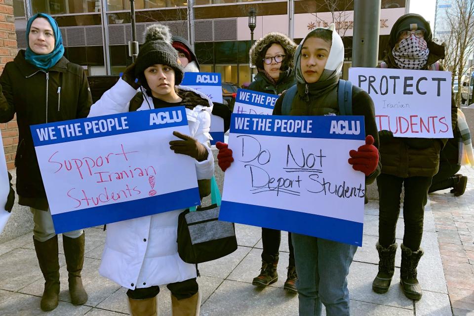 Protesters stand outside the federal courthouse where a hearing was scheduled for Northeastern University student Shahab Dehghani, Tuesday, Jan. 21, 2020, in Boston. Dehghani arrived on a flight into Boston on Monday but was detained by U.S. Customs and Border Patrol at Logan International Airport and then was deported. (AP Photo/Philip Marcelo)