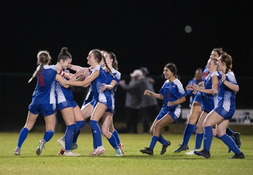 The Patriots swarm Lexi Basel (4) after she scores to win with 11-10 in penalty kicks in overtime during the Pace vs Gulf Breeze girls playoff soccer game at Ashton Brosnaham Park on Friday, Jan. 26, 2024.